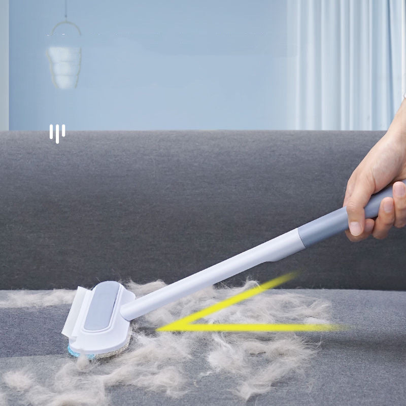 Brosse à manche long utilisée sur un canapé en tissu avec poils visibles